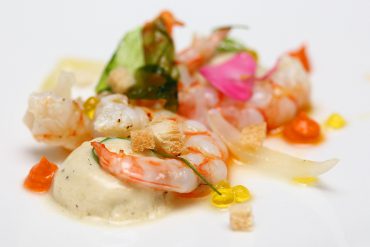 Langostino en salazón con crema helada de ajo tostado, romesco y caviar aceite de oliva