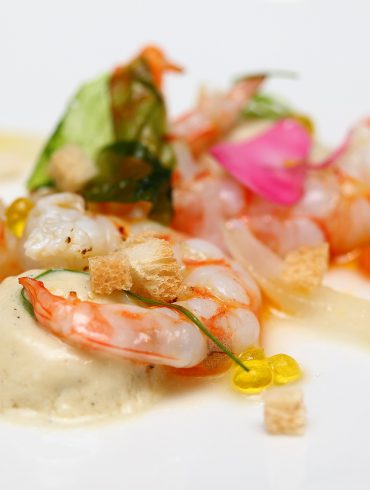 Langostino en salazón con crema helada de ajo tostado, romesco y caviar aceite de oliva